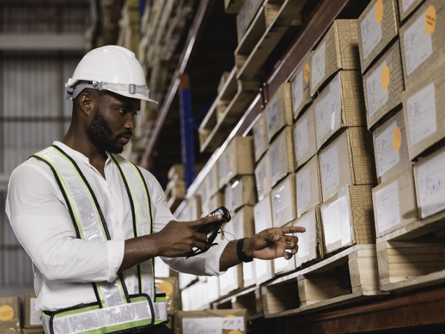 Black male staff using digital barcode scanner working checking stock in logistic warehouse