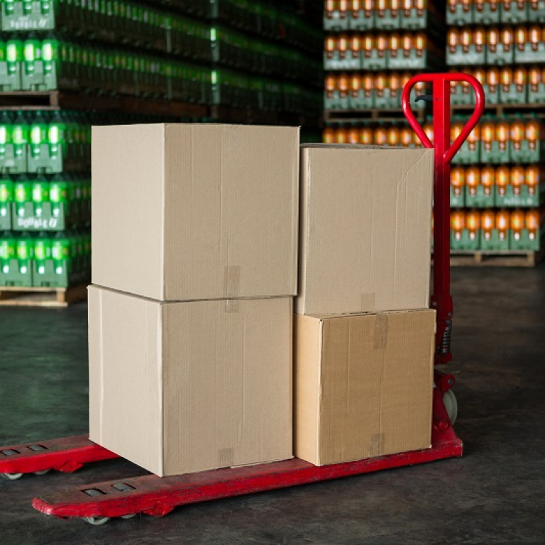 Cardboard boxes on trolley in juice factory