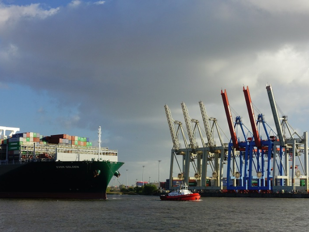 big containership let by a tug boat in hamburg harbor